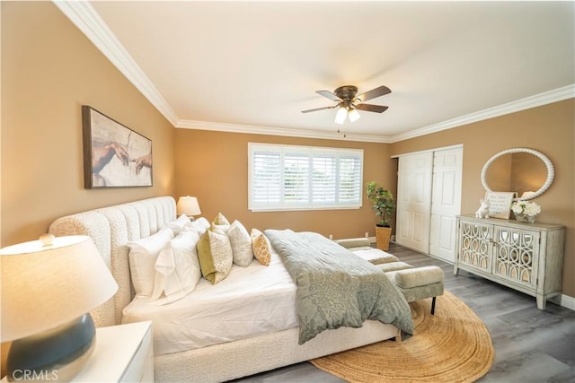 bedroom with a closet, a ceiling fan, ornamental molding, wood finished floors, and baseboards