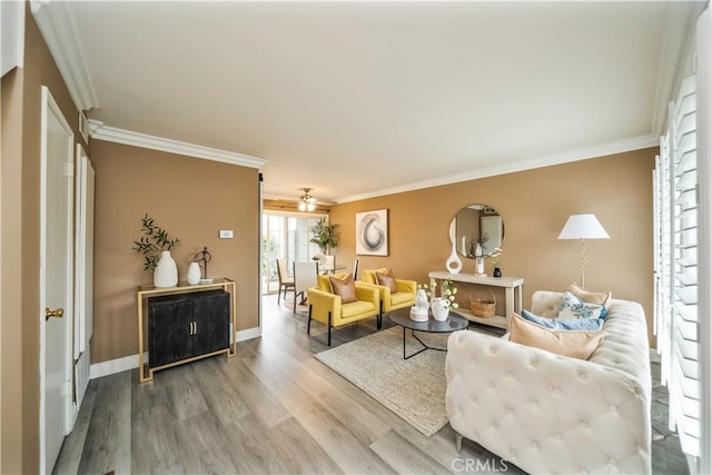 living area with ceiling fan, baseboards, ornamental molding, and wood finished floors