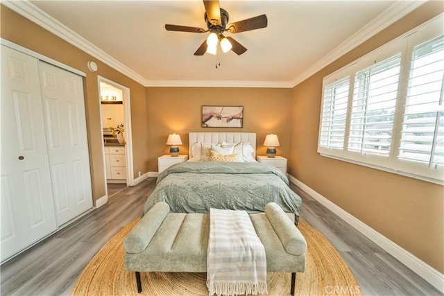 bedroom with crown molding, a closet, a ceiling fan, wood finished floors, and baseboards