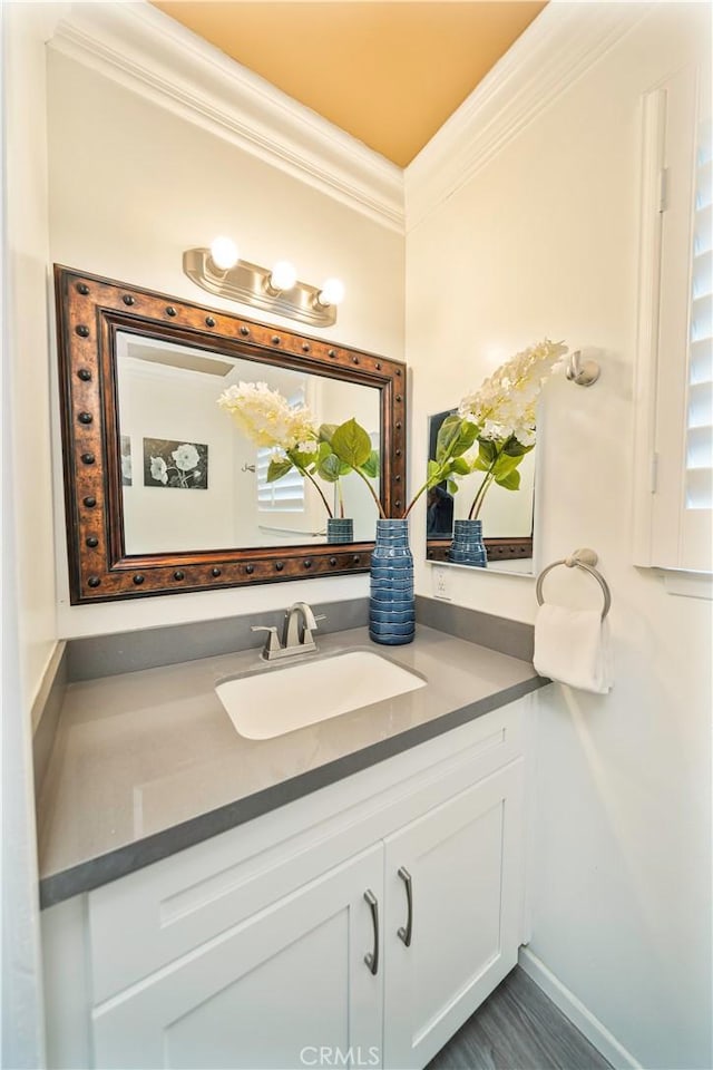 bathroom with crown molding, vanity, and baseboards