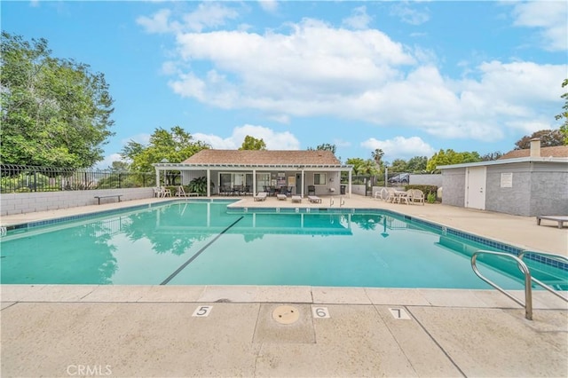 pool with a patio area and fence