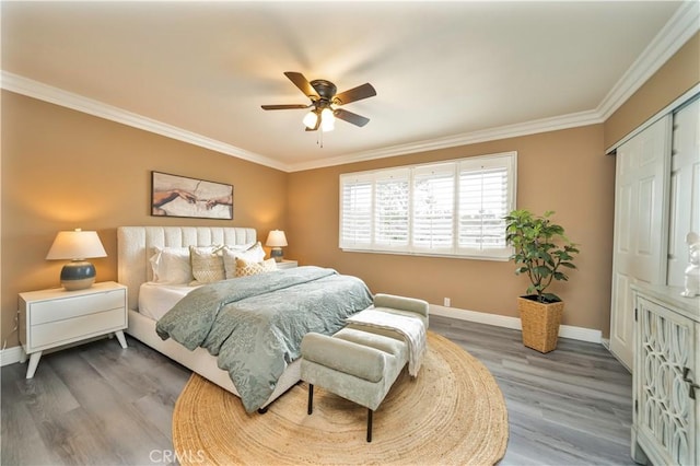 bedroom featuring crown molding, wood finished floors, and baseboards