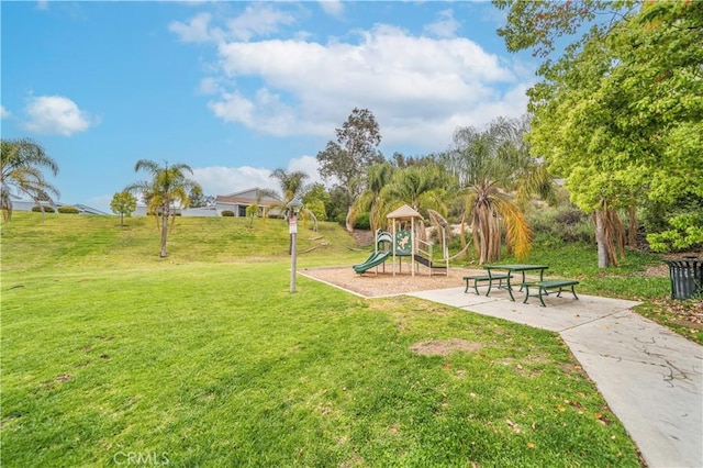 view of property's community with a yard and playground community