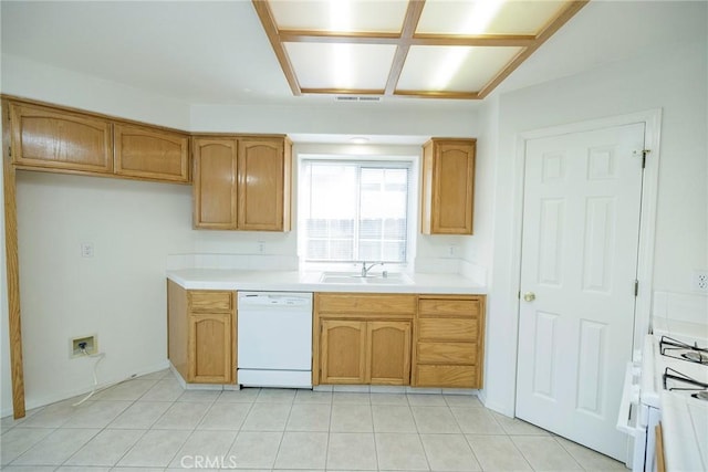 kitchen with light tile patterned floors, white appliances, brown cabinetry, visible vents, and a sink