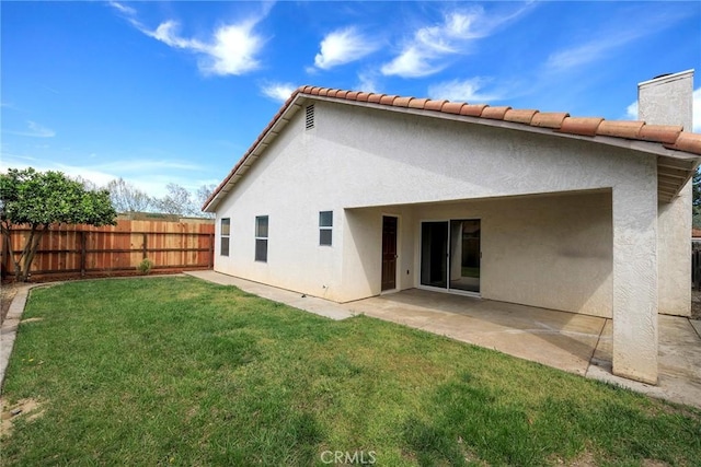 back of house with a yard, fence, and stucco siding