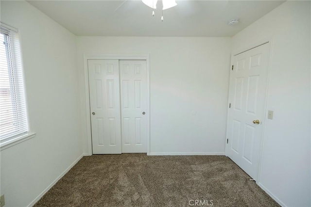 unfurnished bedroom featuring a closet, baseboards, and carpet