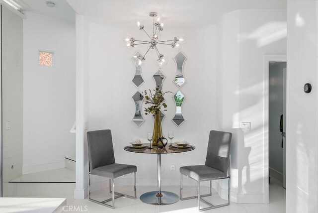 dining room with a chandelier and baseboards