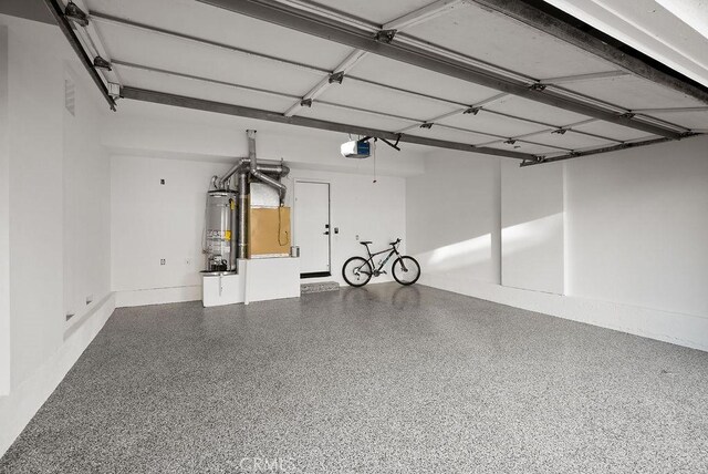 garage with gas water heater and a garage door opener