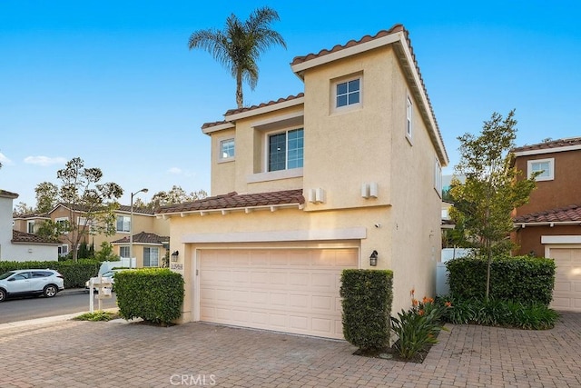 199 Las Flores, Aliso Viejo, CA 92656 - view of property featuring a tile roof, stucco siding, a garage, and decorative driveway