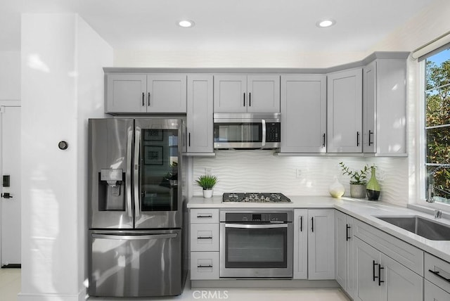 199 Las Flores, Aliso Viejo, CA 92656 - kitchen featuring appliances with stainless steel finishes, gray cabinetry, light countertops, tasteful backsplash, and a sink