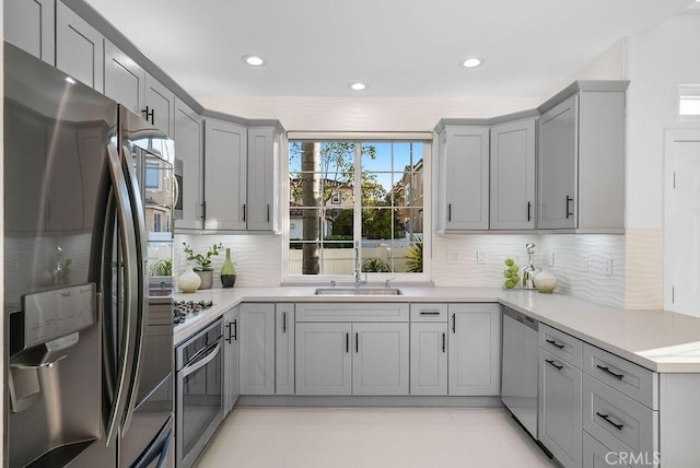 kitchen with stainless steel appliances, gray cabinetry, tasteful backsplash, light countertops, and recessed lighting