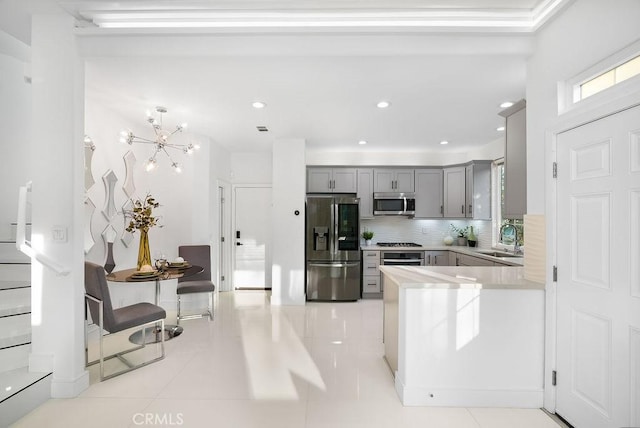 199 Las Flores, Aliso Viejo, CA 92656 - kitchen with appliances with stainless steel finishes, gray cabinetry, a sink, decorative backsplash, and light countertops