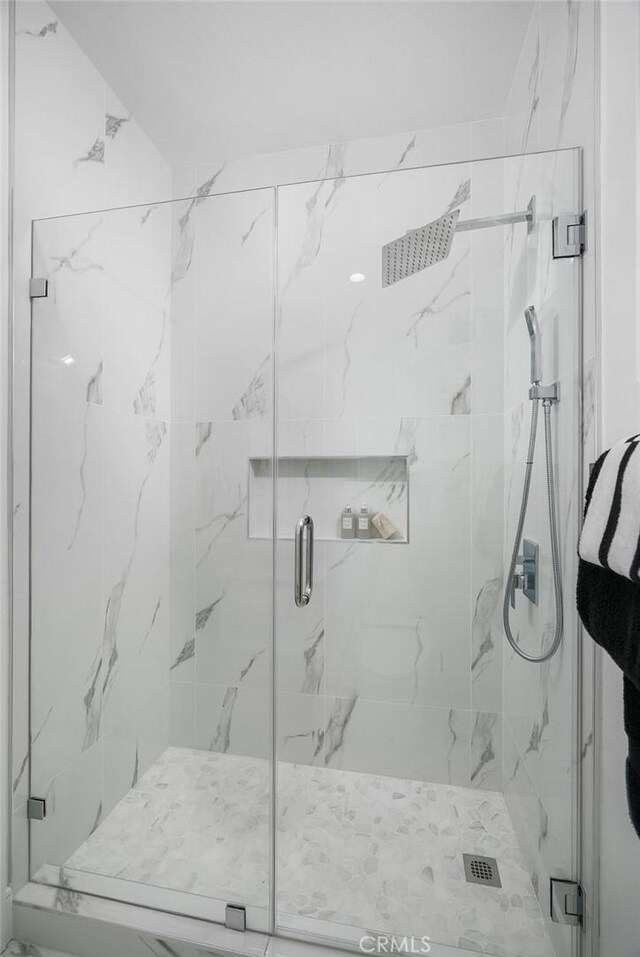 bathroom featuring a marble finish shower