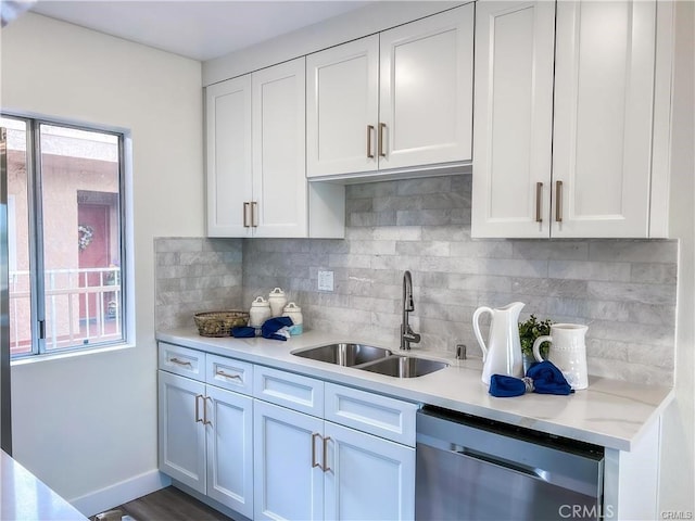 kitchen with a sink, dishwasher, white cabinets, and light countertops