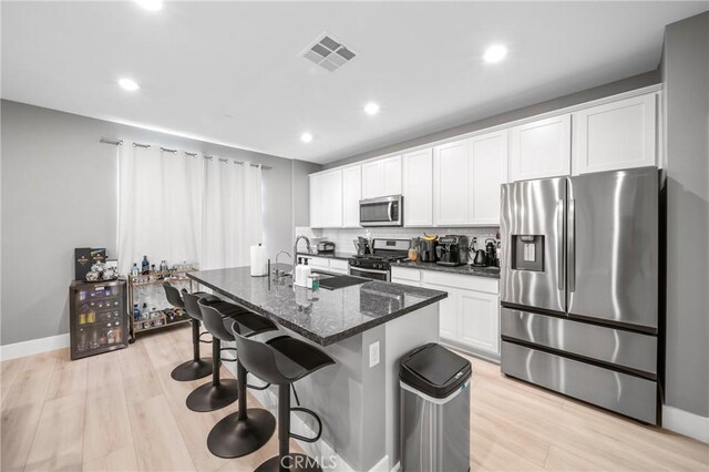 5313 Mariner Ln, Chino, CA 91710 - kitchen with visible vents, a sink, appliances with stainless steel finishes, an island with sink, and a breakfast bar area