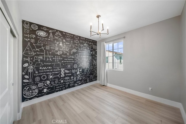 5313 Mariner Ln, Chino, CA 91710 - empty room with an accent wall, baseboards, a notable chandelier, and wood finished floors
