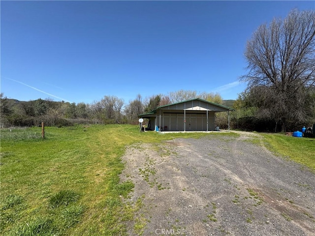 exterior space featuring an outbuilding, a garage, an outdoor structure, and a lawn