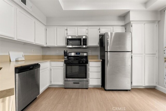 kitchen featuring white cabinets, light wood-style flooring, light countertops, and appliances with stainless steel finishes