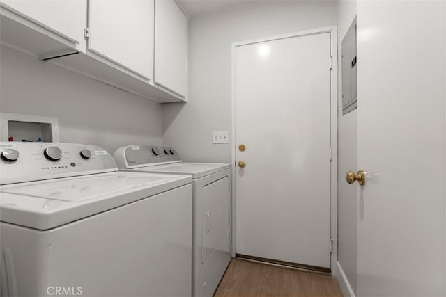 laundry room with cabinet space, washing machine and clothes dryer, and light wood finished floors