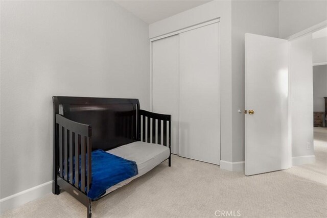 bedroom featuring baseboards, carpet floors, and a closet