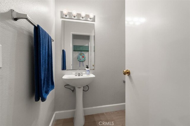 bathroom featuring baseboards and a sink