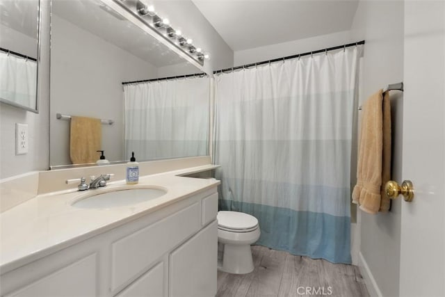 bathroom featuring curtained shower, wood finished floors, toilet, and vanity