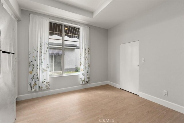 spare room with wood finished floors and baseboards
