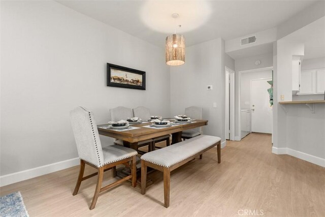 dining area featuring light wood-type flooring, baseboards, and visible vents