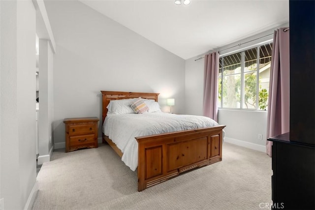 bedroom with vaulted ceiling, baseboards, and light carpet
