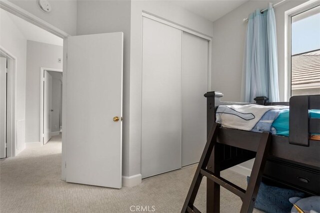 bedroom featuring a closet, carpet flooring, and baseboards