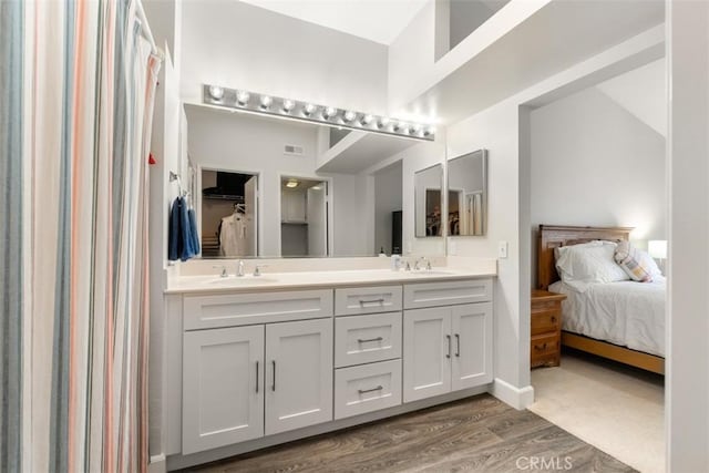 full bathroom featuring double vanity, wood finished floors, ensuite bath, and a sink