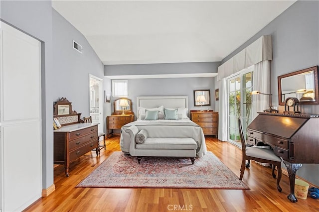 bedroom with lofted ceiling, visible vents, light wood finished floors, and multiple windows