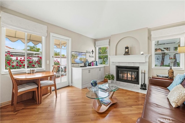living room featuring a tile fireplace and light wood-style floors