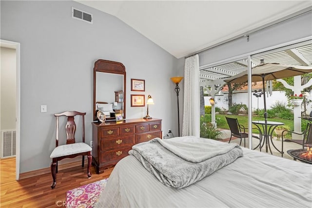 bedroom featuring vaulted ceiling, visible vents, wood finished floors, and access to outside