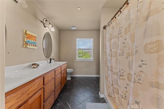 bathroom featuring a shower with curtain, toilet, a sink, double vanity, and baseboards