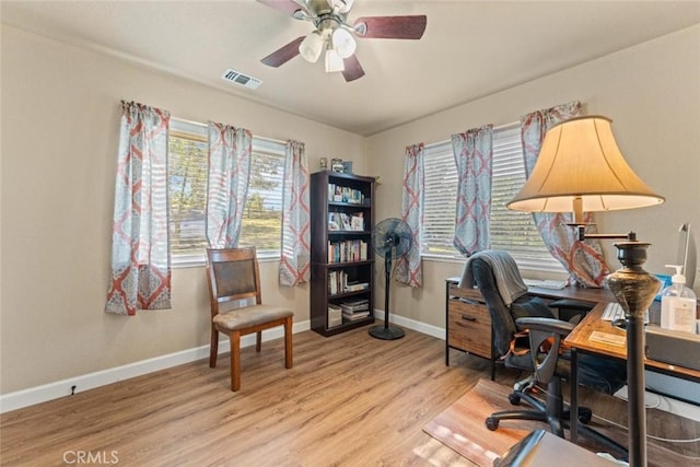 office space with visible vents, baseboards, a ceiling fan, and wood finished floors