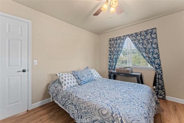 bedroom featuring wood finished floors, baseboards, and a ceiling fan