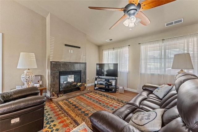 living area featuring visible vents, baseboards, vaulted ceiling, and wood finished floors