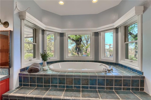 bathroom featuring a wealth of natural light, recessed lighting, vanity, and a garden tub
