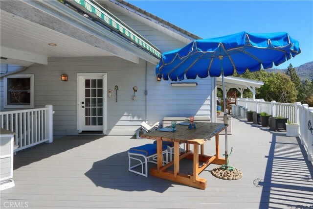wooden terrace featuring outdoor dining area and a mountain view