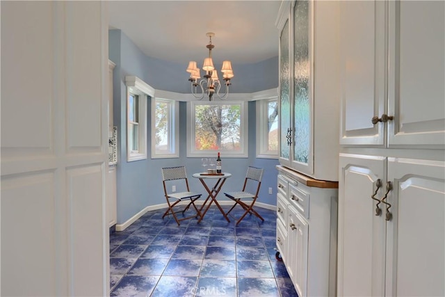 dining room featuring baseboards and an inviting chandelier