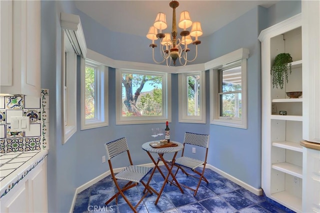 dining space with a chandelier and baseboards