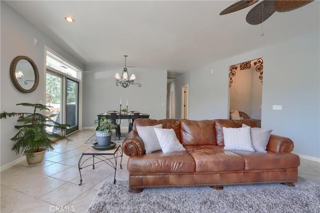 living room featuring baseboards, ceiling fan with notable chandelier, and light tile patterned flooring