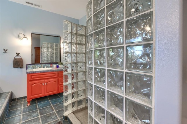 full bath featuring a walk in shower, tile patterned flooring, vanity, and visible vents