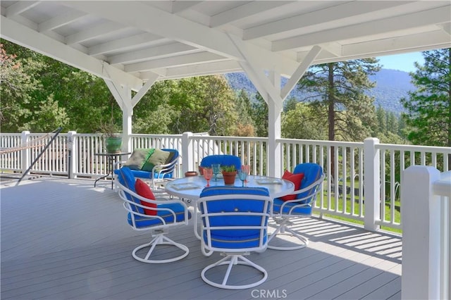 wooden deck with a mountain view and outdoor dining space