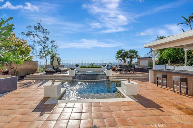 view of pool with outdoor dry bar, a fenced backyard, outdoor dining area, and a patio area
