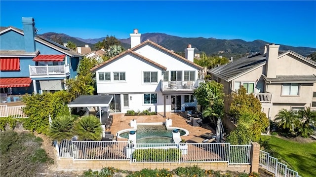 back of property featuring a mountain view, a fenced backyard, a chimney, and stucco siding