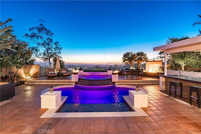 view of pool with a fenced in pool, a patio area, a fenced backyard, and outdoor dry bar