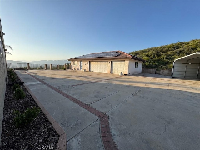 11901 Sunset Ridge Dr, Yucaipa, CA 92399 - view of front facade with a garage, solar panels, and stucco siding