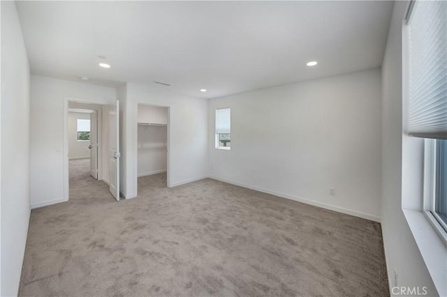 unfurnished bedroom featuring carpet flooring, multiple windows, and recessed lighting